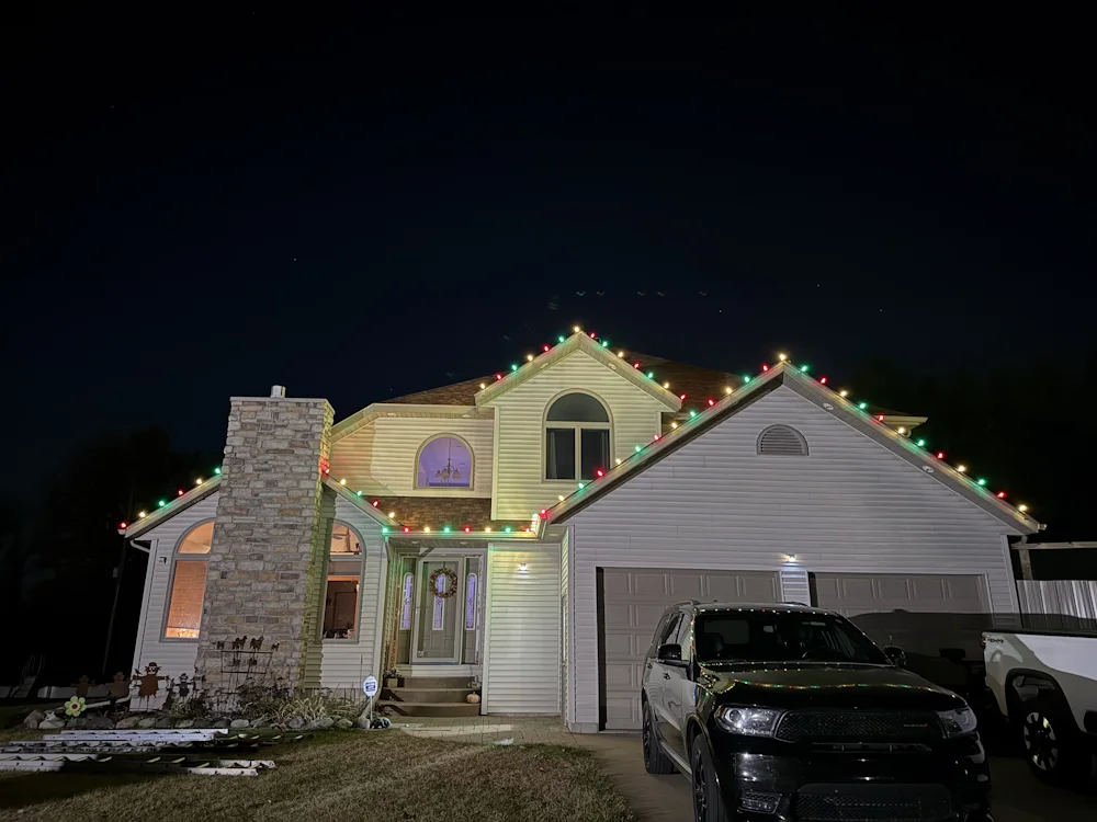 Residential roofline decorated with colorful holiday lights