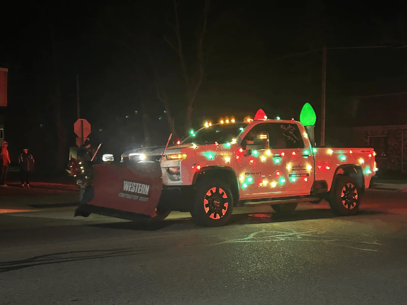 AMPM service truck decorated with oversized colorful lights at the 2024 Standish Santa Parade